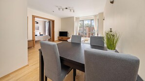 A modern dining area with a dark wooden table and grey upholstered chairs.