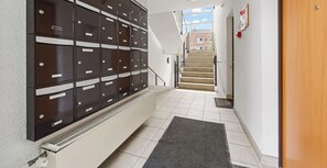 A stairway leading to a landing with a row of metal storage lockers.