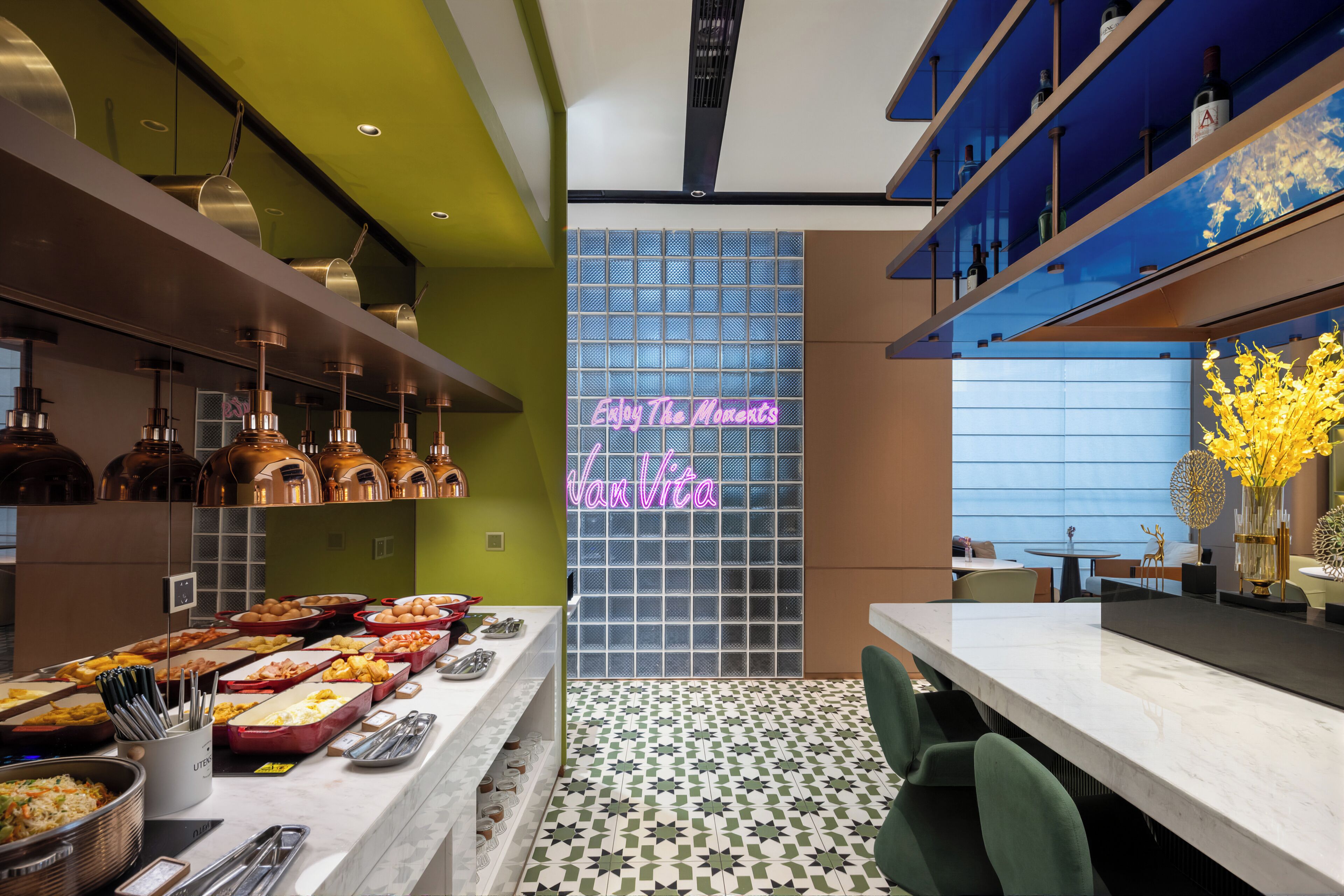A modern restaurant interior with a buffet, neon sign, and a patterned floor.