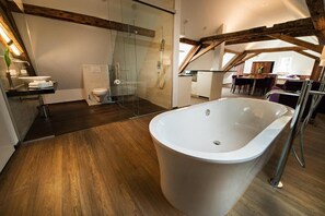 A modern bathroom with a freestanding bathtub, a glass shower enclosure, and a wooden floor. - Gasthof zum Hecht Fehraltorf (Fehraltorf)
