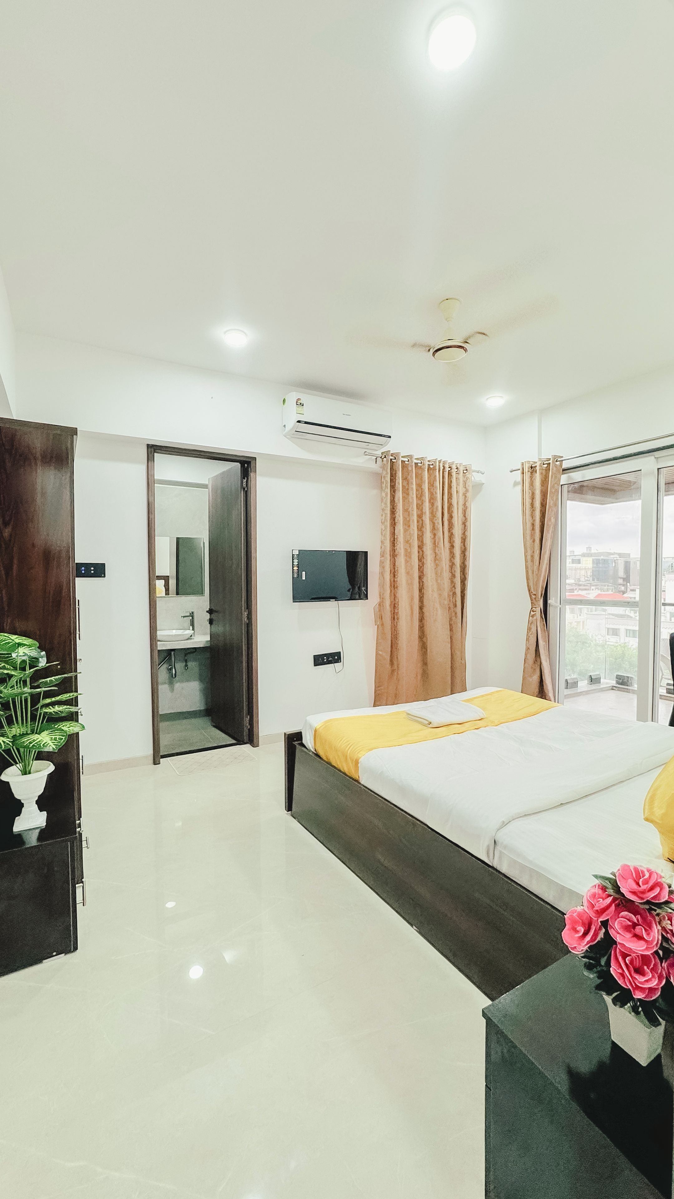 Une chambre d’hôtel équipée d’un lit, d’une télévision, de la climatisation, d’une salle de bain et offrant une vue sur l’extérieur.
