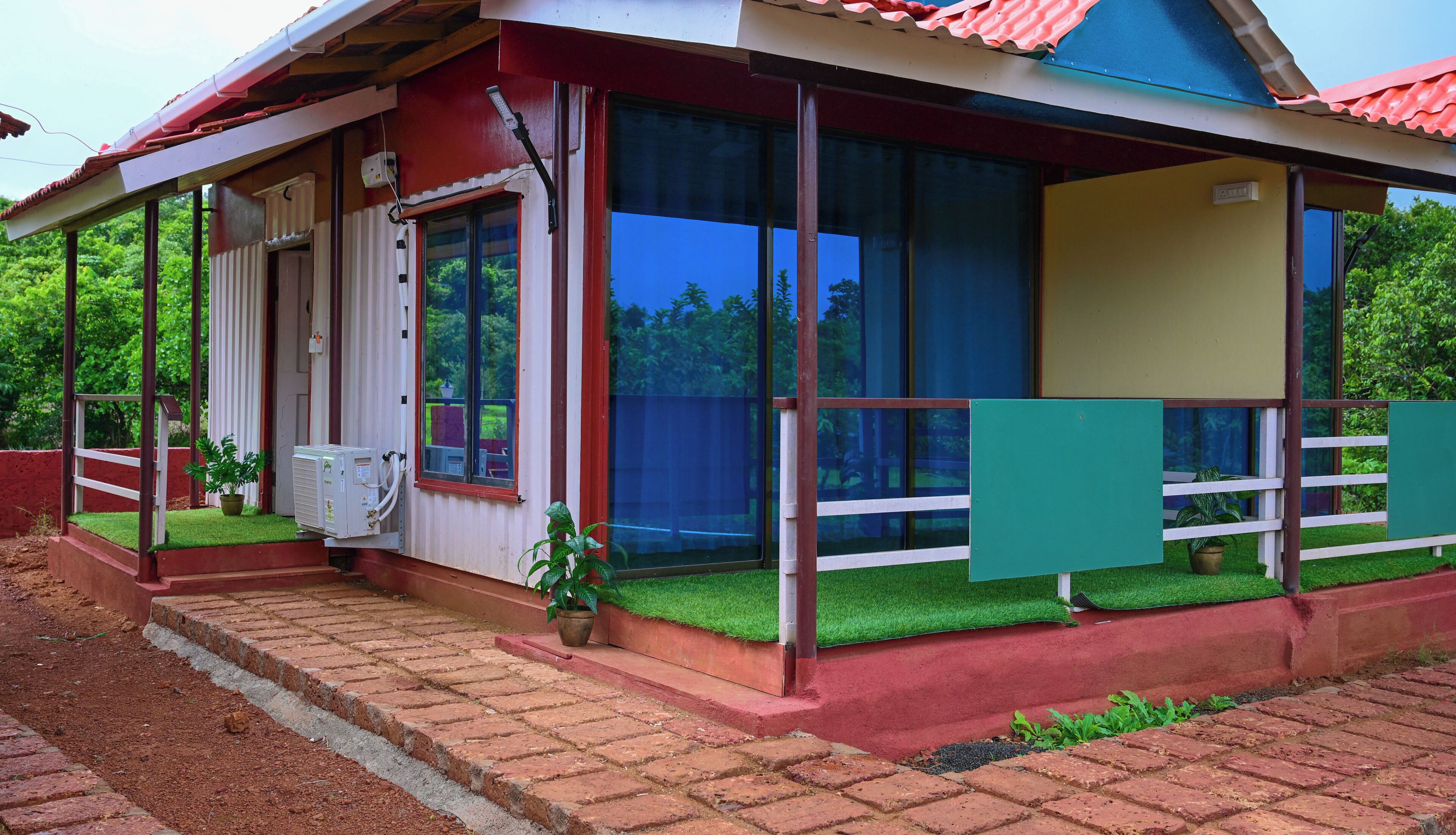 A single-story building with a red and white exterior, large windows, and a covered porch area.