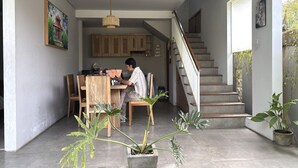 Ein Wohndachboden mit Essbereich, Treppe und Blumentöpfen.