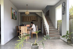 A home interior with a dining area, staircase, and potted plants. - Twin Room Near Sanur Beach (Bali)