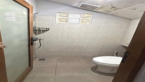 Ein kleines Badezimmer mit Toilette, Duschbereich und Waschbecken.