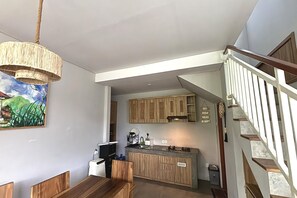 Une cuisine moderne avec des meubles en bois, un îlot central intégré et un luminaire suspendu.
