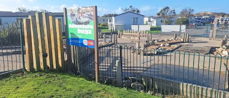 A fenced area with a sign advertising an adventure buggy ride for £9.50 per person.