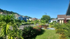 A residential area with houses, a clear sky, and lush greenery. - Beyond Escape-Solar-Powered-3BDRM-Near Ocho Rios (Boscobel)