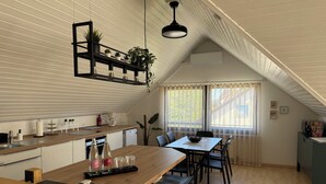 A modern kitchen with a wooden countertop, a bar area, and a dining table with chairs. - Nordi Living Apartment—ideally located in the heart of Baden-Württemberg (Horb am Neckar)