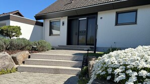 A modern house with a tiled roof, a front door, and a paved driveway leading to the entrance. - Nordi Living Apartment—ideally located in the heart of Baden-Württemberg (Horb am Neckar)