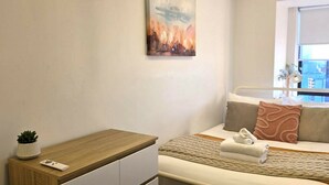 Ein Schlafzimmer mit Bett, Nachttisch und einem Fenster mit Blick.