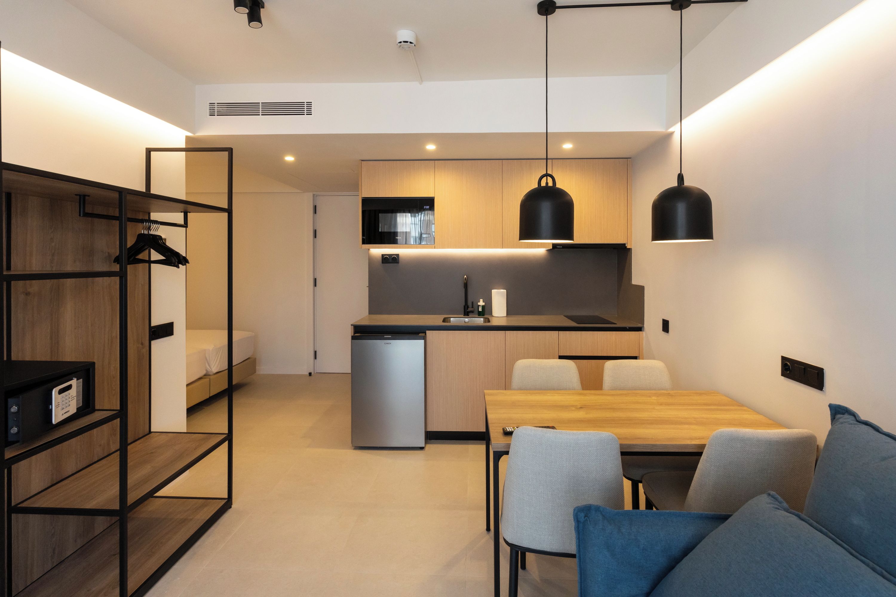 Une petite cuisine moderne équipée d’un four à micro-ondes, d’un évier et d’un réfrigérateur compact.