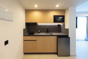 A modern kitchen with wooden cabinets, a built-in microwave, and a dishwasher.