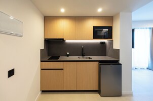 Una cocina moderna con armarios de madera, microondas integrado y lavavajillas.