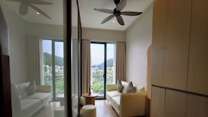Un salon moderne avec un canapé, un pouf et un ventilateur de plafond.