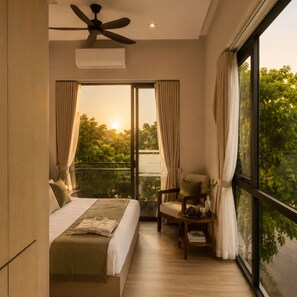 Un dormitorio con cama, una silla, una mesa y vistas a árboles a través de una ventana.