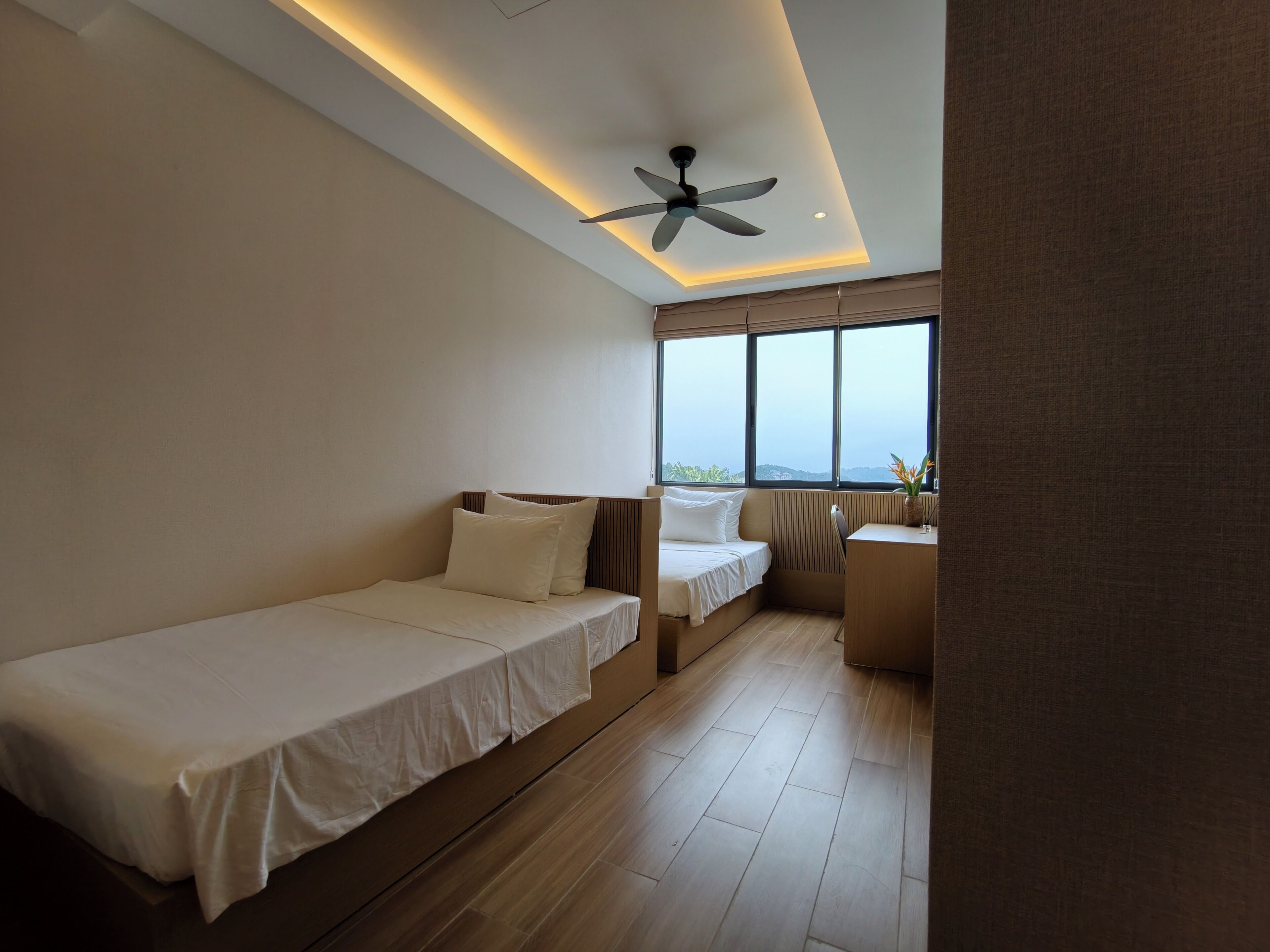 Habitación de hotel moderna con cama, escritorio y vistas al exterior.