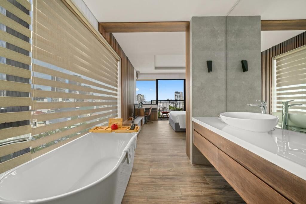 A modern bathroom with a bathtub, a large mirror, and a vanity with a sink.