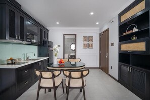 Una cucina moderna con mobili scuri, un tavolo da pranzo rotondo e uno specchio decorativo.