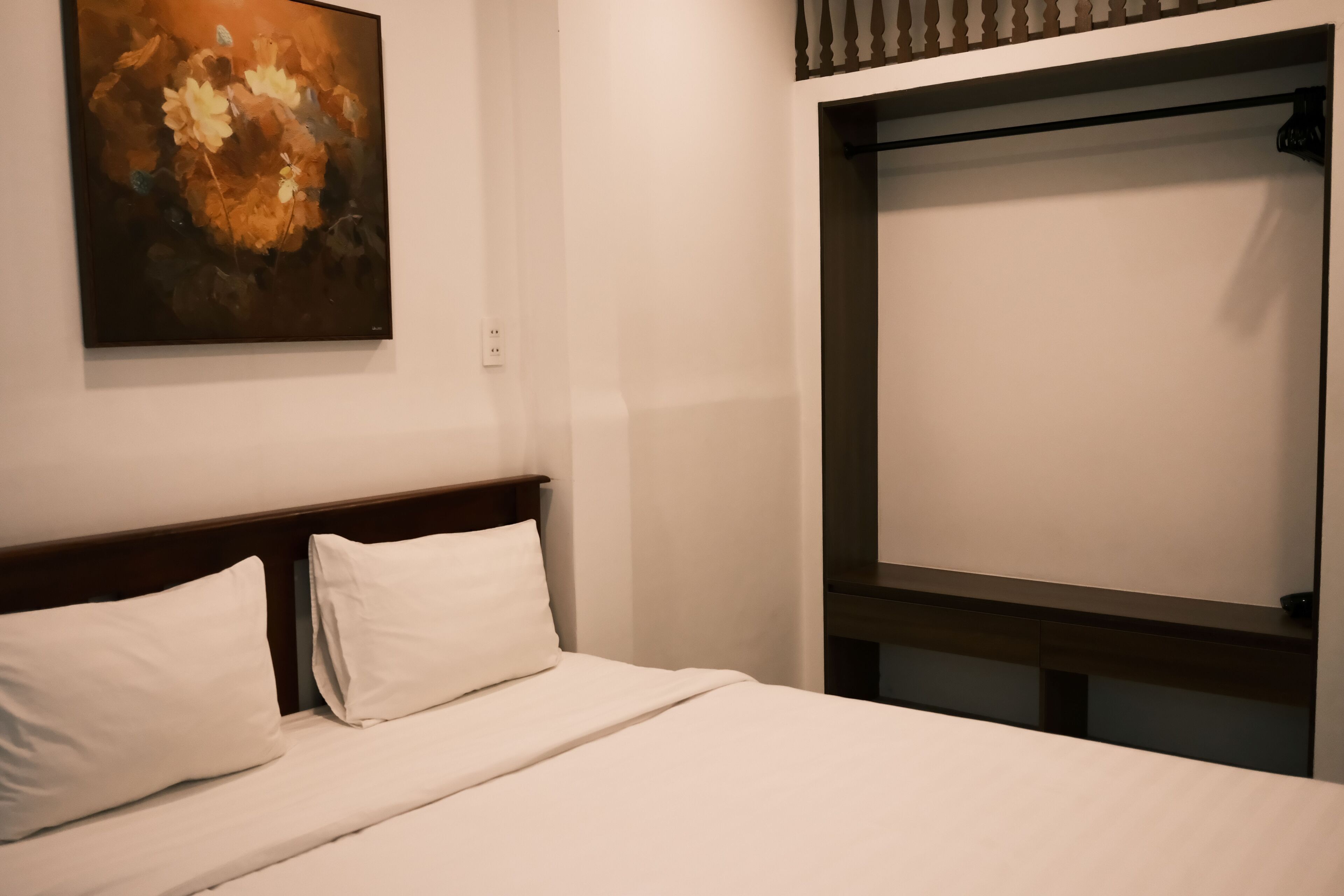 Ein Hotelzimmer mit einem Bett, einem Bild an der Wand und einem Fenster mit Blick.