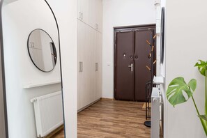 A hallway with a radiator, a mirror, a double door, and a plant. - Central Prague Vinohrady Apt, Near Parks & Cafes (Hlavní město Praha)