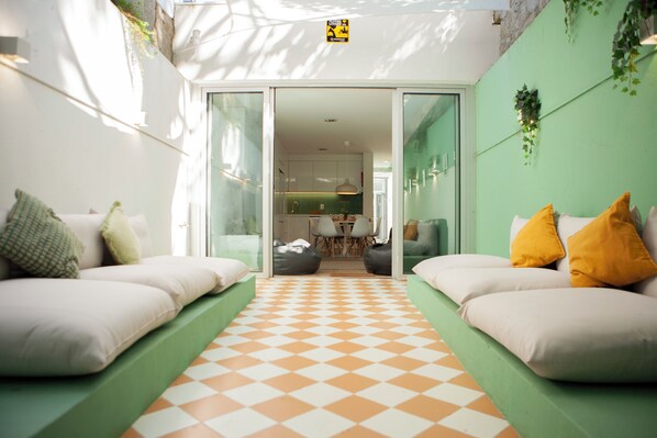 A modern interior with a checkered floor, green walls, and a view into a kitchen area. - PORTO CONCEPT HOME - CAMPO ALEGRE (Porto)