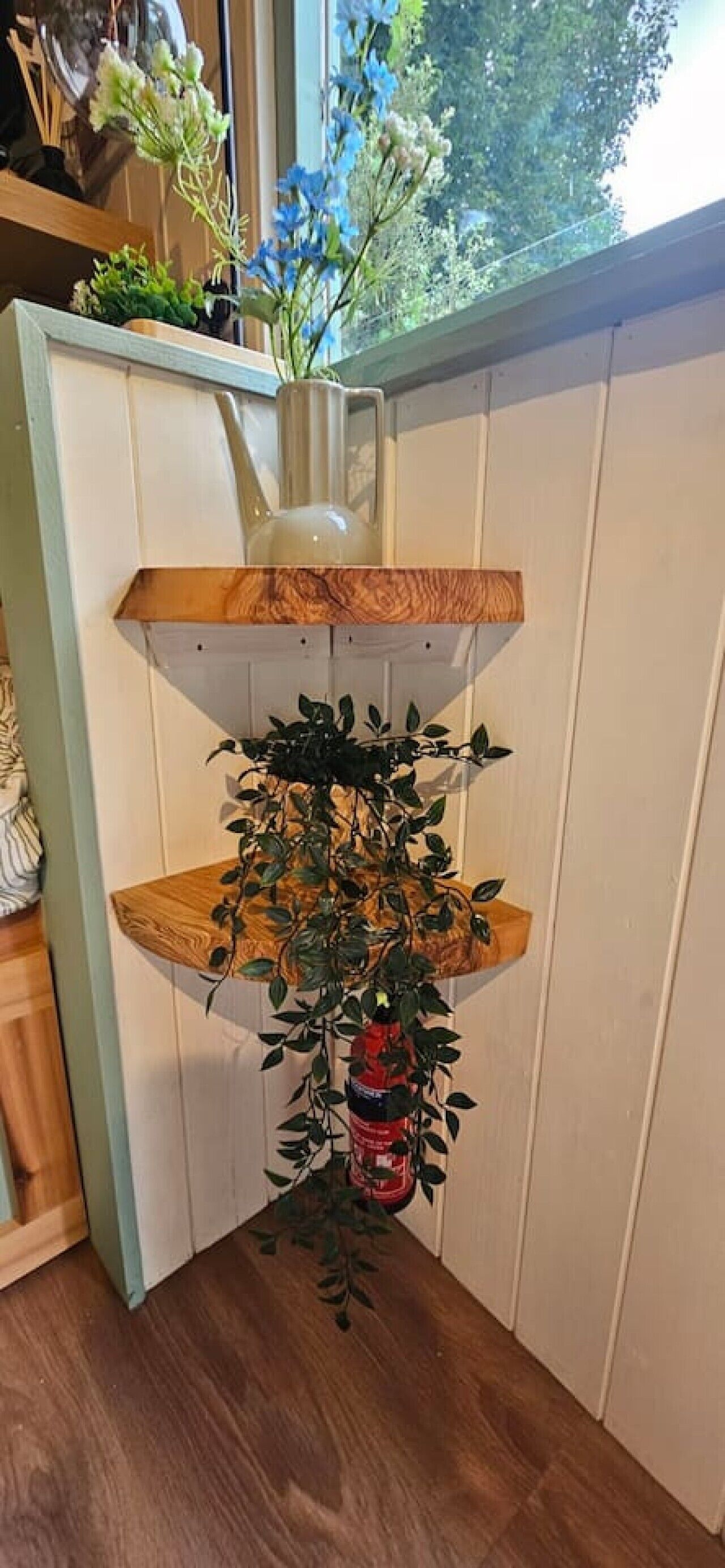 A corner shelf unit with multiple levels, each holding different items.