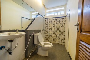 A small bathroom with a sink, toilet, and shower. - Cozzy Villa Omah Nongko (yogyakarta)