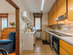 Une cuisine de taille réduite, équipée d’un réfrigérateur, d’une cuisinière et d’un évier.
