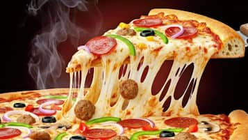 A slice of pizza with various toppings, including pepperoni, sausage, and vegetables, being lifted from a whole pizza.