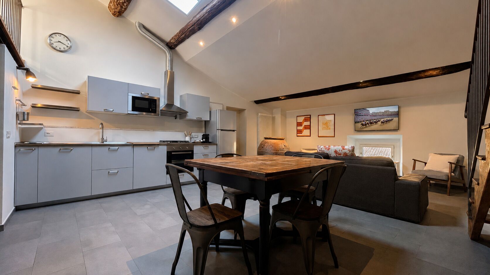 A modern kitchen with a dining area, a clock, and a fireplace.