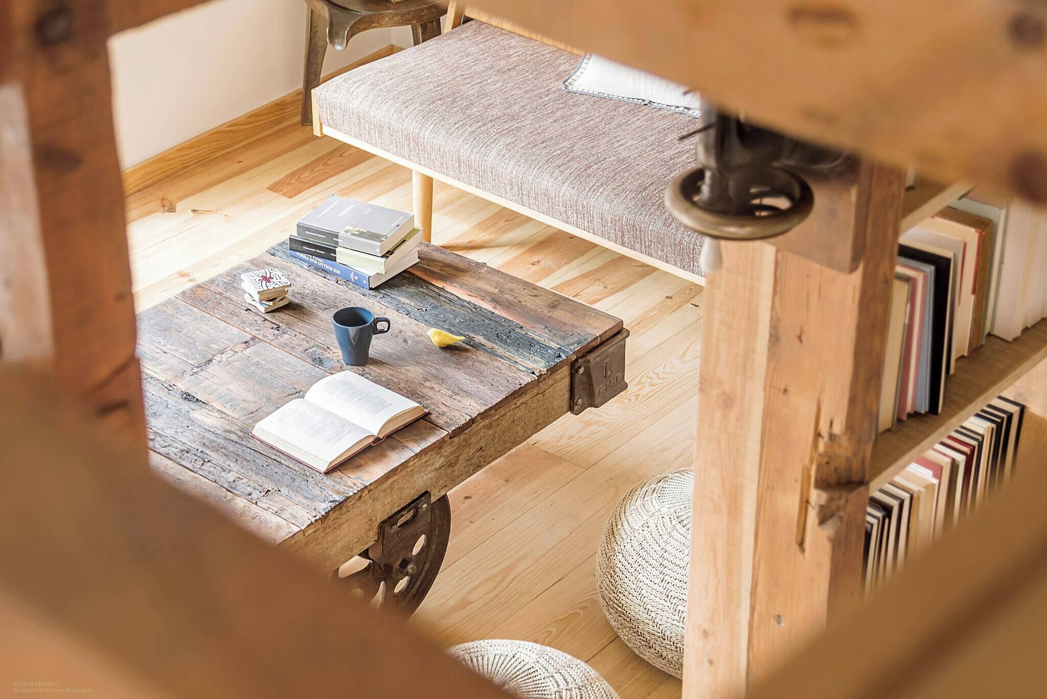 A rustic wooden table with books, a mug, and a small decorative item.