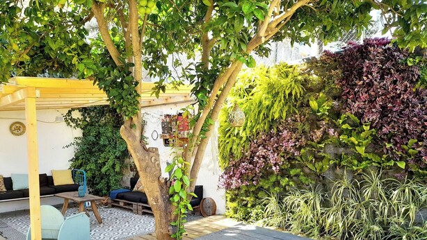 A wooden deck with a bench, a table, and a covered seating area with cushions. - Charming Mouraria Apartment With Private Terrace in Lisbon (Lisbon)