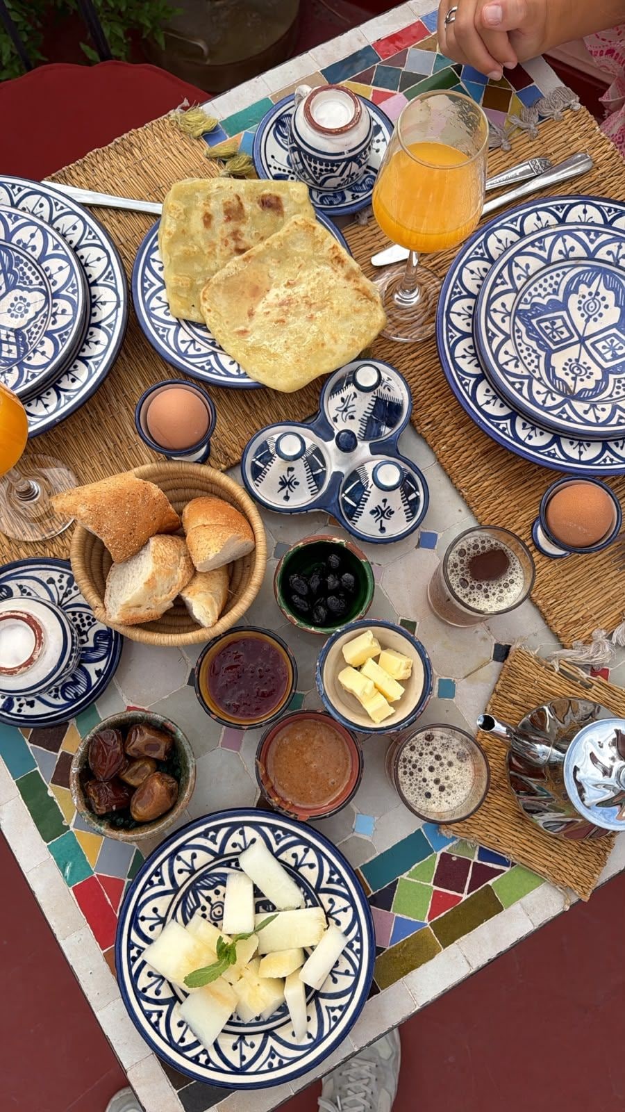 A table set with various breakfast items including bread, eggs, and beverages.