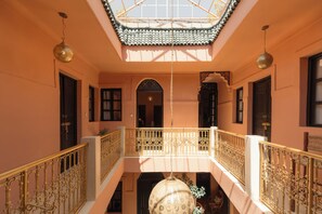 A multi-level interior with ornate railings, a central open space, and a ceiling with a patterned design. - Riad Hima by Assila (Marrakech)