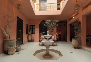A spacious courtyard with a central fountain, potted plants, and seating areas. - Riad Hima by Assila (Marrakech)