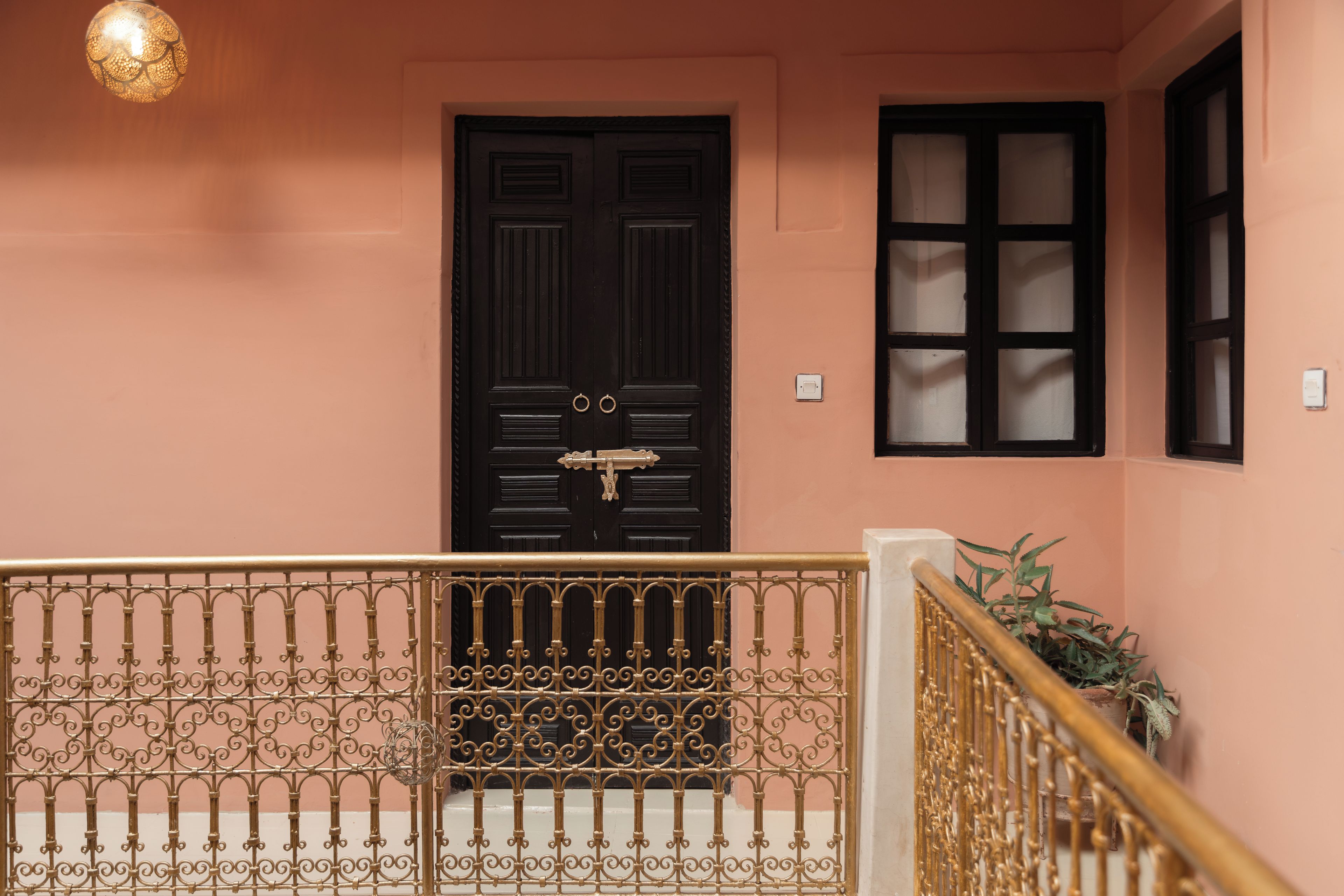 A staircase with a black door and a window with multiple panes.
