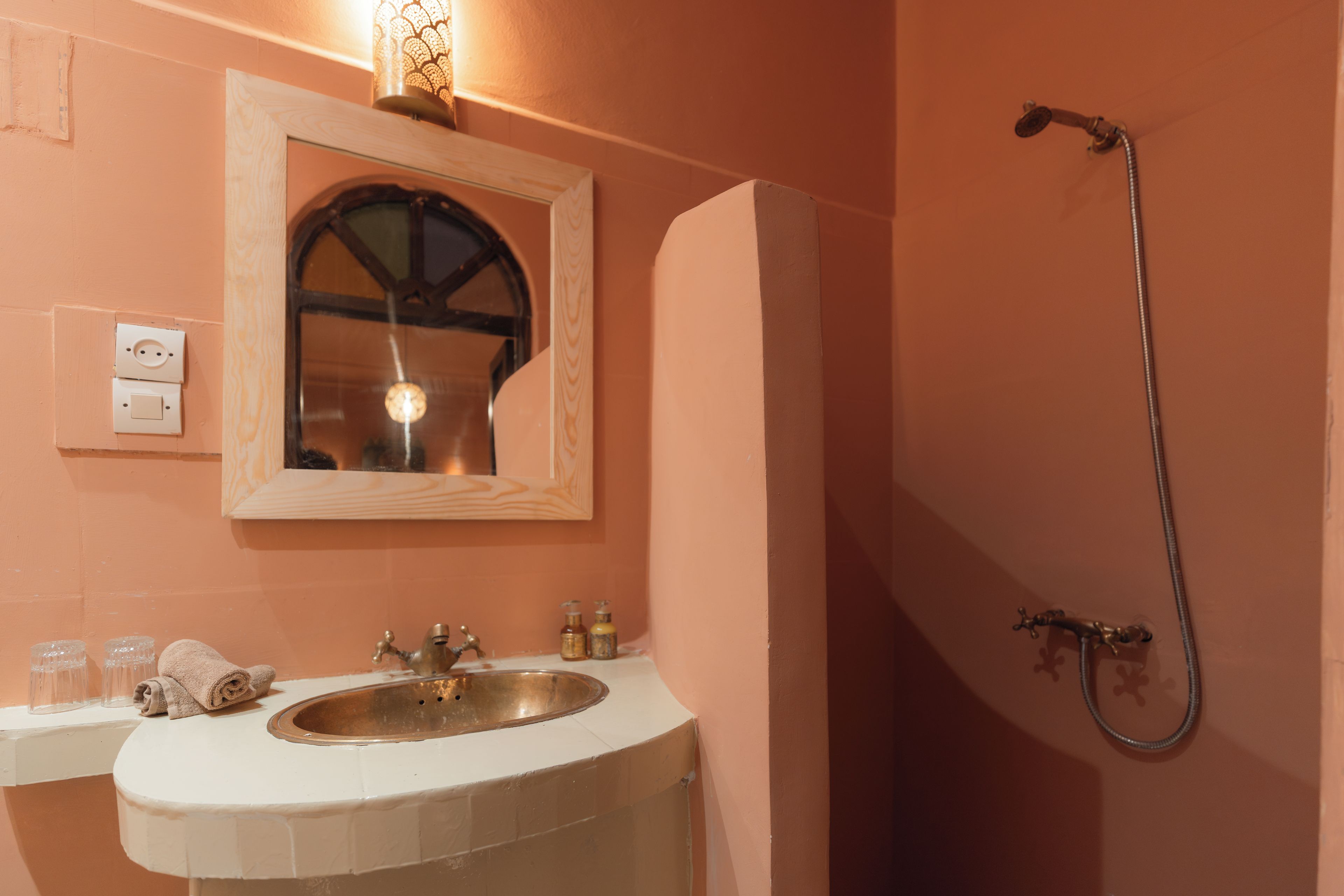 Un baño con lavamanos, espejo y ducha.