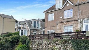 Un quartier résidentiel caractérisé par des murs en pierre, une clôture en bois et des maisons aux toits en pente.