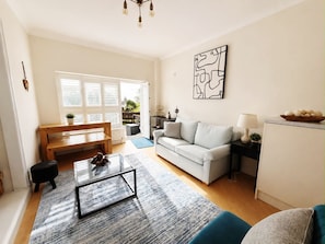 Ein modernes Wohnzimmer mit Sofa, Couchtisch und einem Essbereich mit einer Bank und Tisch.