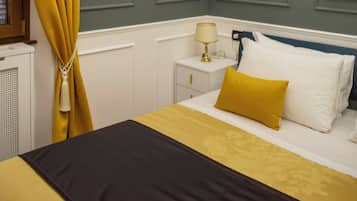 Un dormitorio con cama, mesita de noche, lámpara y candelabro.