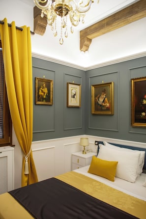 Un dormitorio con cama, mesita de noche, lámpara y candelabro.