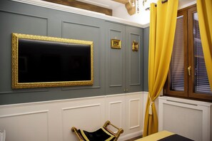 Una habitación con un espejo grande enmarco, una cama con cabecera y una ventana con cortinas.