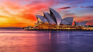 Sydney Opera House med sin karakteristiske sejldesign, beliggende ved vandet.