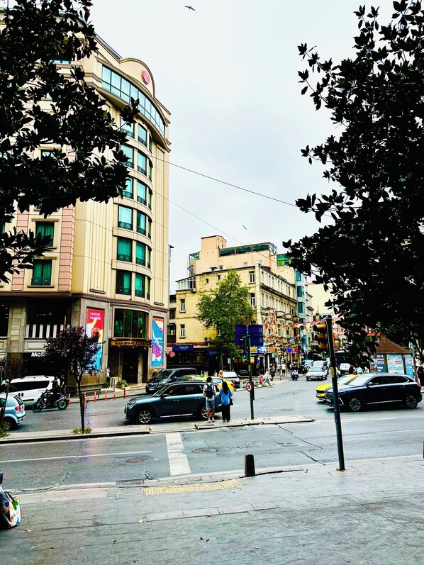 Vista de la calle con edificios, un paso de peatones y vehículos.