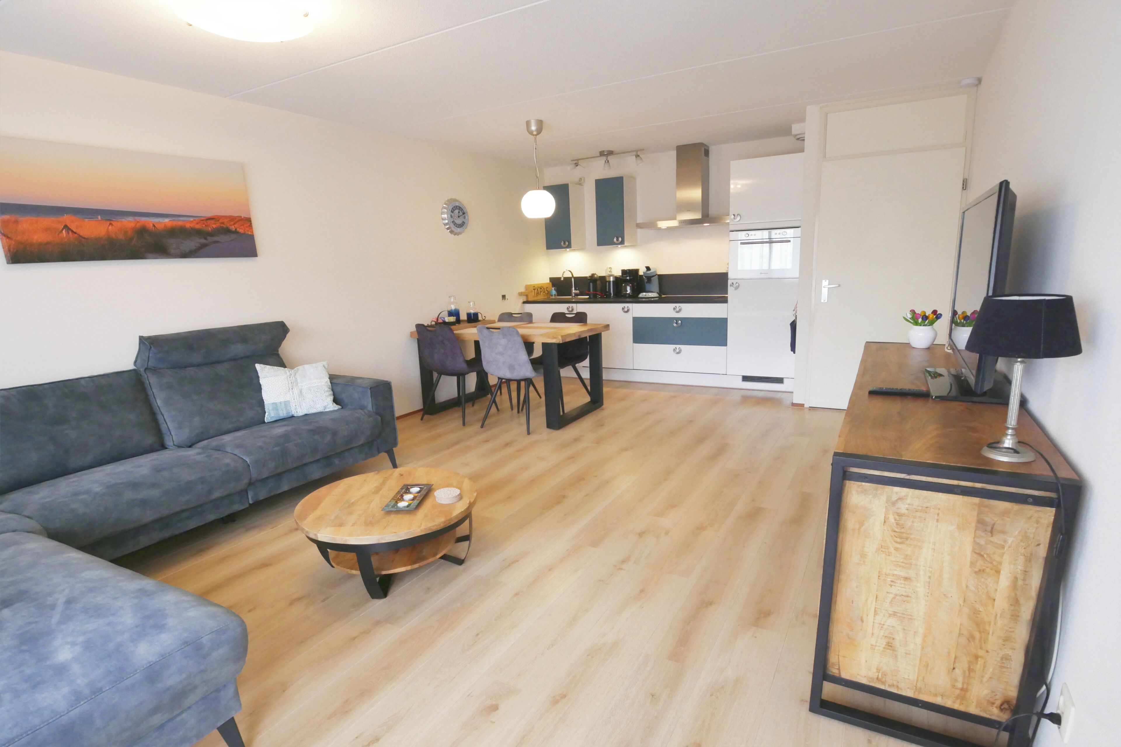 A modern living room with a sofa, coffee table, and dining area.