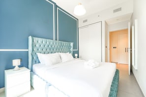 Ein Hotelzimmer mit einem großen Bett, einem Nachttisch, einer Lampe und einem Kleiderschrank.