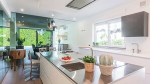 Una cocina moderna con una isla central, electrodomésticos de acero inoxidable y un amplio ventanal que proporciona luz natural.