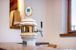 A coffee machine with a gold and white design, a tap, and a label on top.