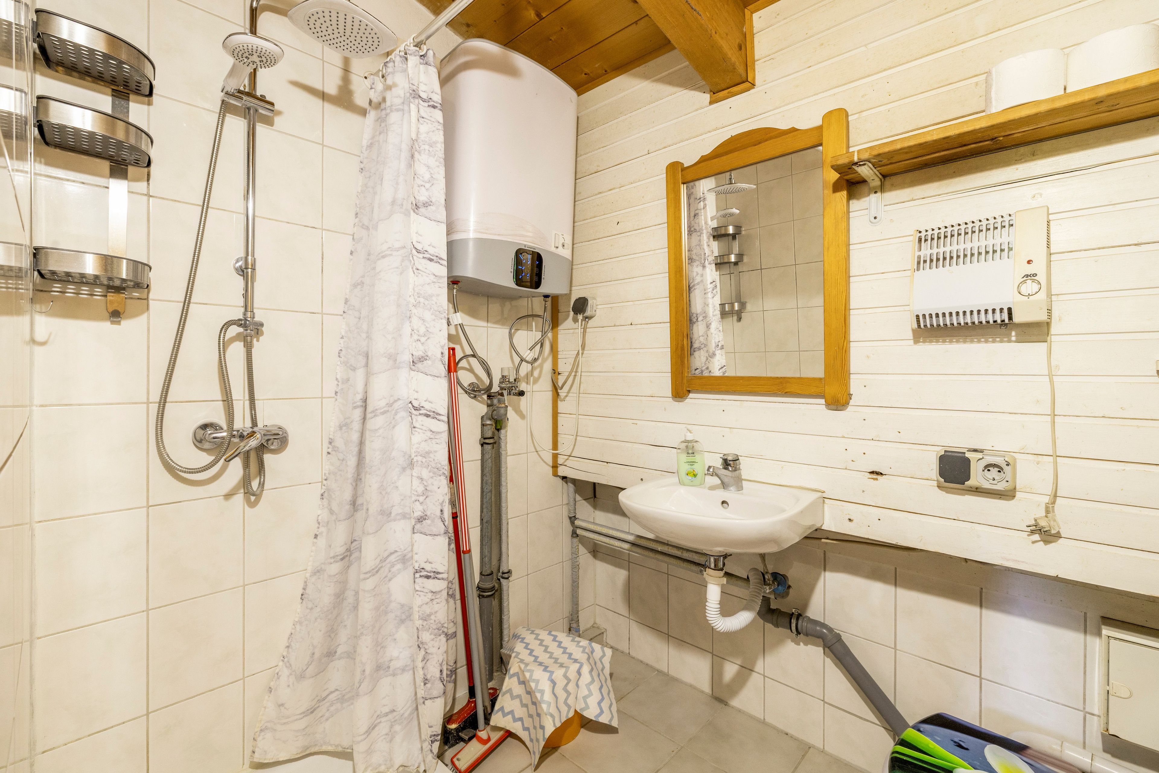 Ein Badezimmer mit Dusche, Waschbecken und Spiegel.